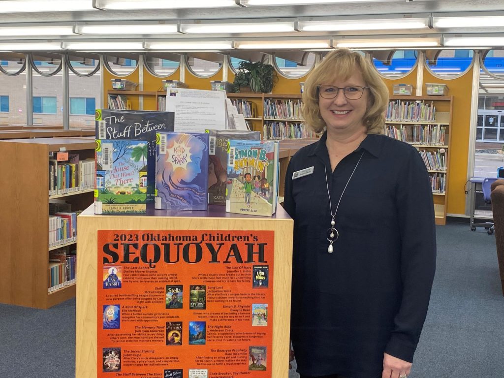 Librarian Susan Shewey standing next to Children's Sequoyah books