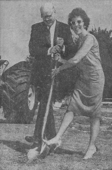 FIRST SPADEFUL - Mayor Herb Bullard and Librarian Jean Harrington join forces to turn over the first spadeful of earth for the new library to be built on the south side of the Enid square. Ground breaking ceremonies were held at the site Friday morning with work to begin immediately on construction of the half million dollar building.