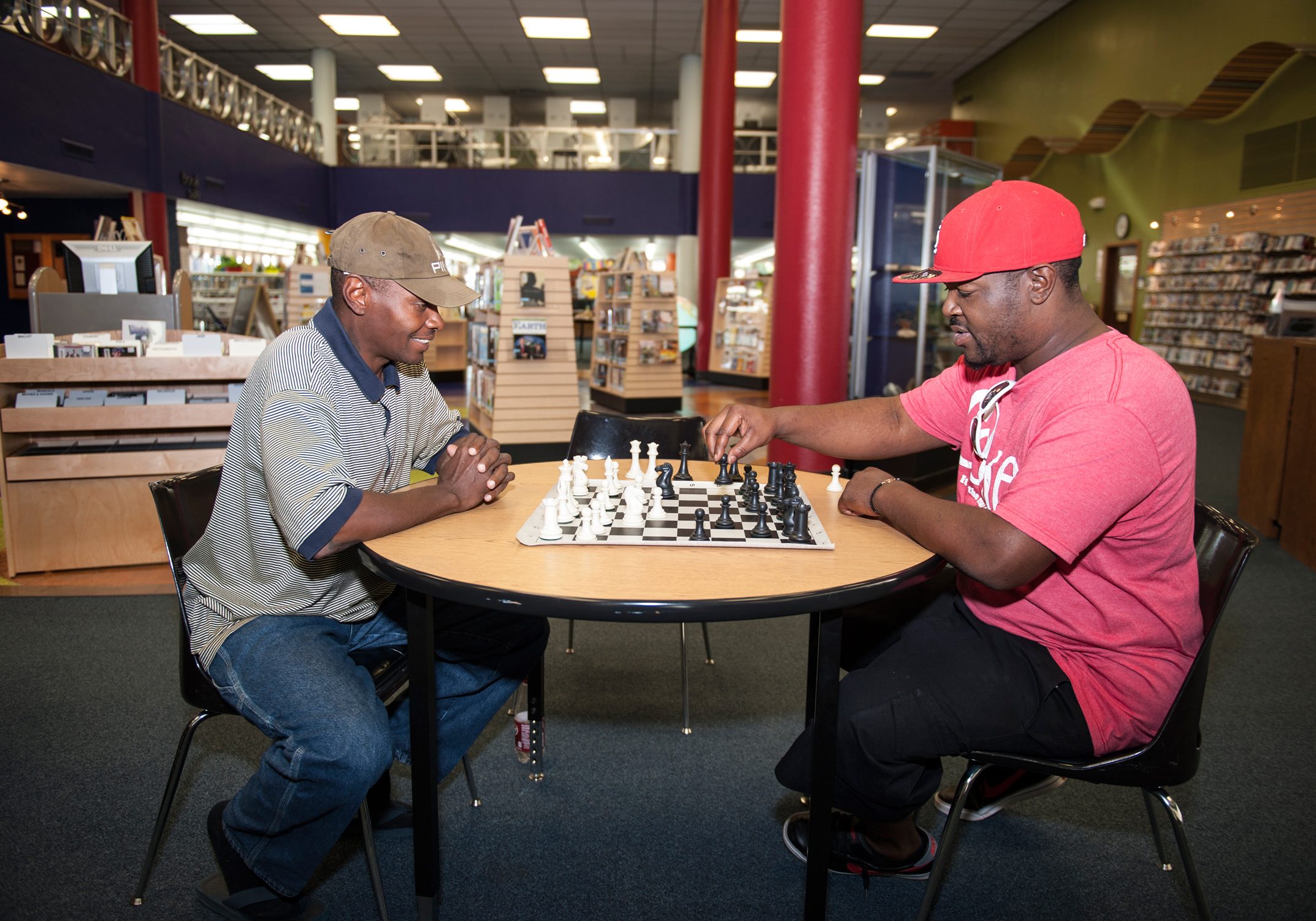 two guys playing chess in the library